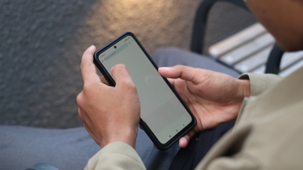overhead photo of two hands cradling a phone — surveillance-photo composition